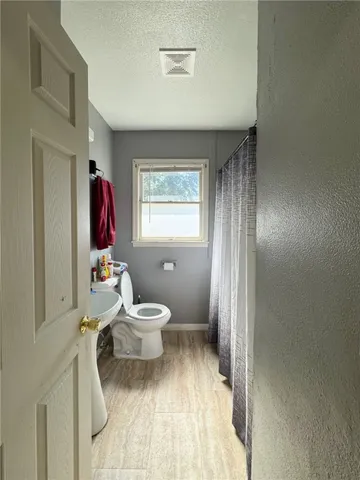 a bathroom with a sink toilet and window