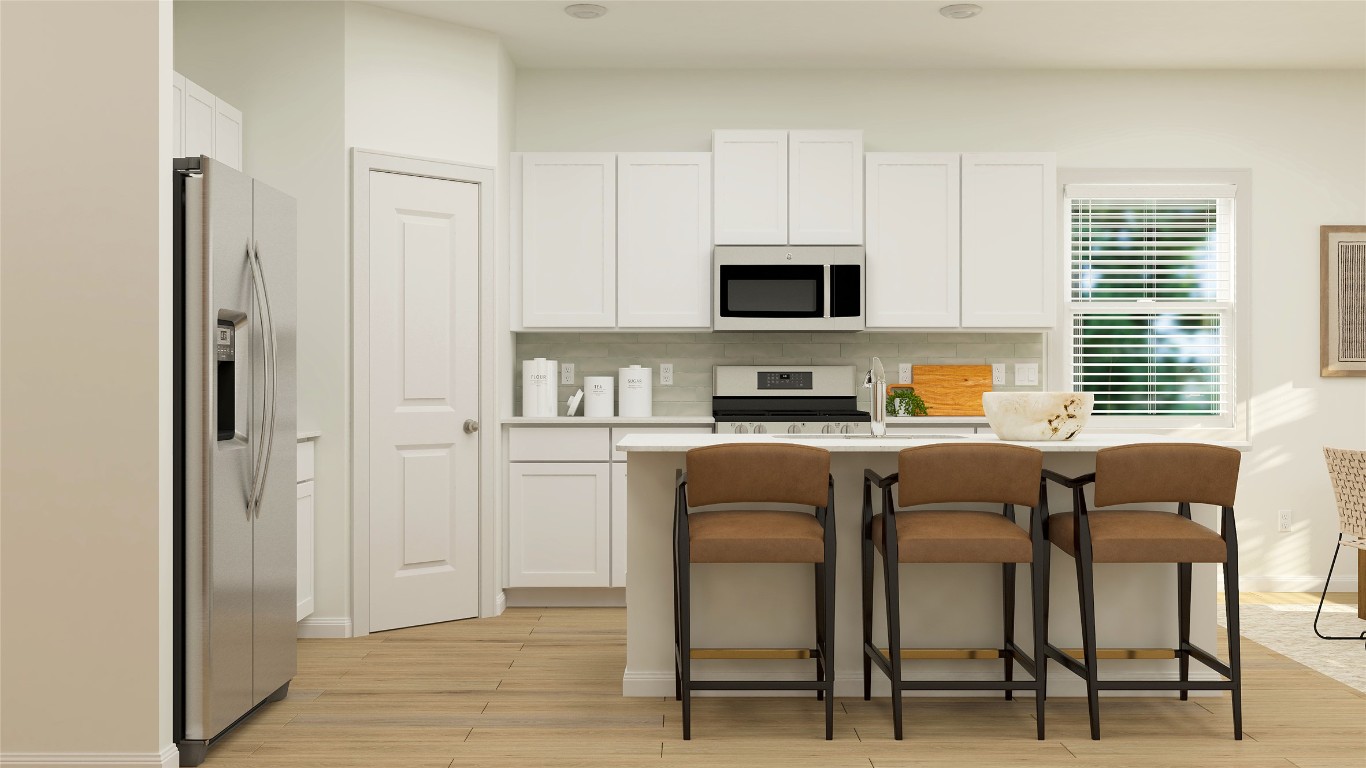 18017 Prairie Falcon Way Pflugerville, TX 78660 - Photo 21 of 26 a kitchen with stainless steel appliances granite countertop a stove a sink and a refrigerator