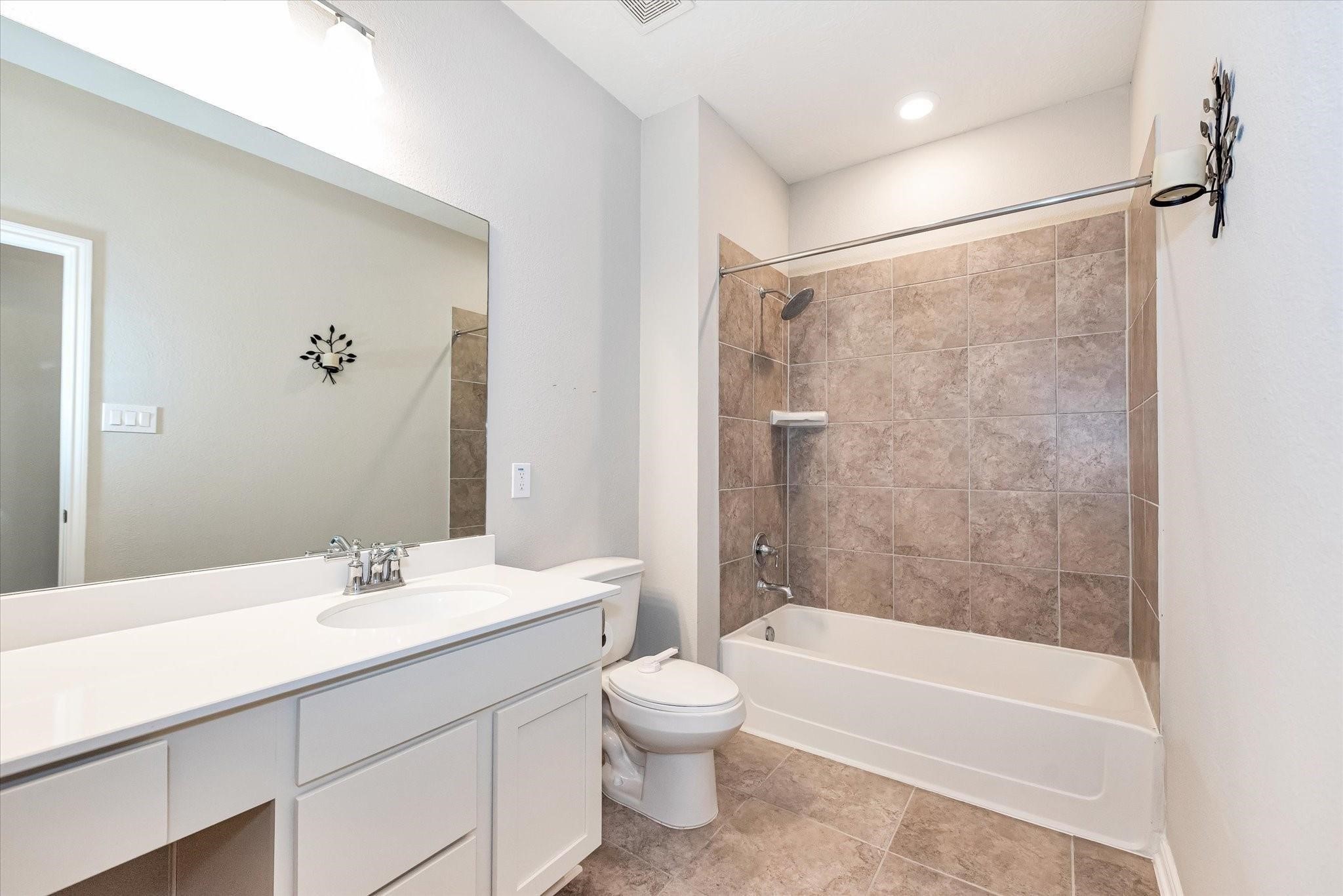 1111 Swinford Court Conroe, TX 77304 - Photo 15 of 21 a bathroom with a granite countertop sink a toilet and shower