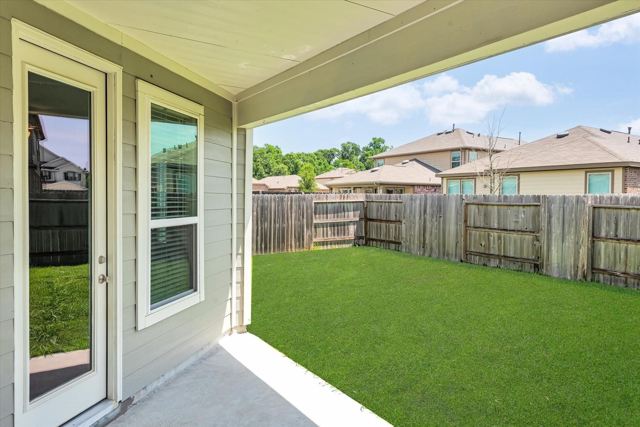 1111 Swinford Court Conroe, TX 77304 - Photo 20 of 21 a view of a backyard with floor to ceiling window and wooden fence