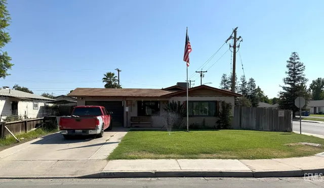 a front view of a house with a garden and trees