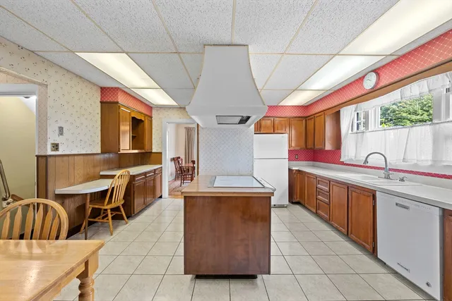 a dining hall with stainless steel appliances granite countertop a sink and cabinets