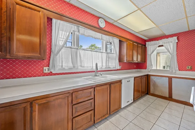 a kitchen with granite countertop a sink and dishwasher a stove with wooden floor