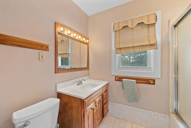 a bathroom with a granite countertop sink toilet and shower