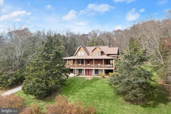 a view of a house with a big yard plants and large trees