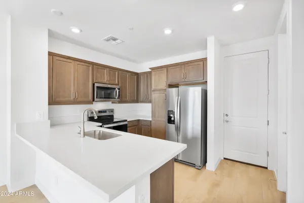 a kitchen with stainless steel appliances a refrigerator sink and microwave