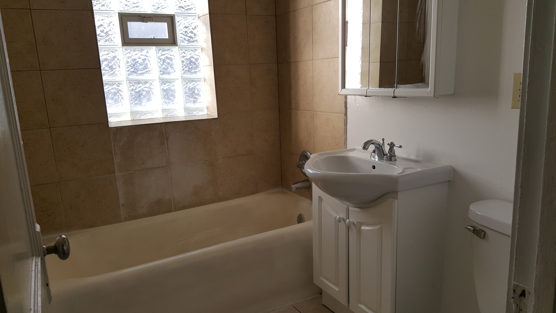 8758 South May Street, Unit 2S Chicago, IL 60620 - Photo 5 of 5 a bathroom with a sink bathtub and a window