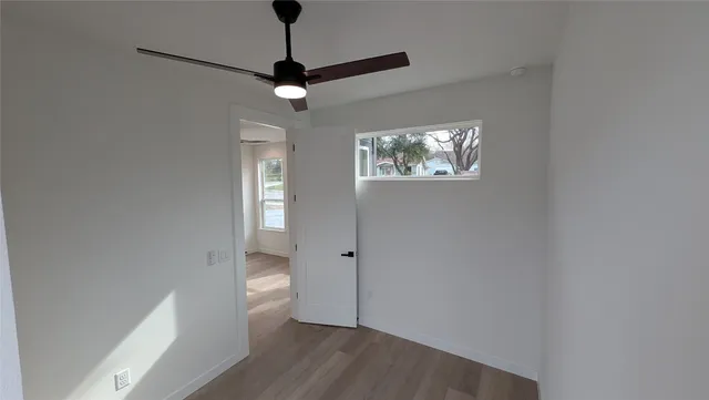 a view of a house with a large tree and wooden fence