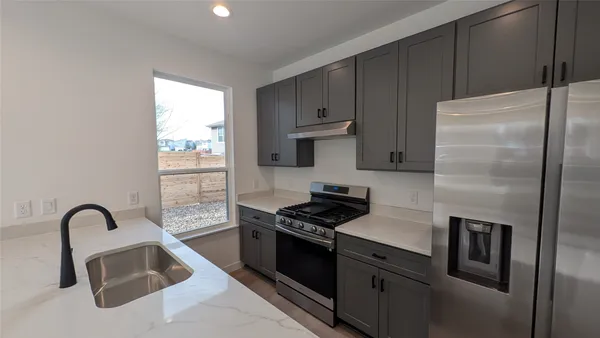 a kitchen with a refrigerator stove and sink