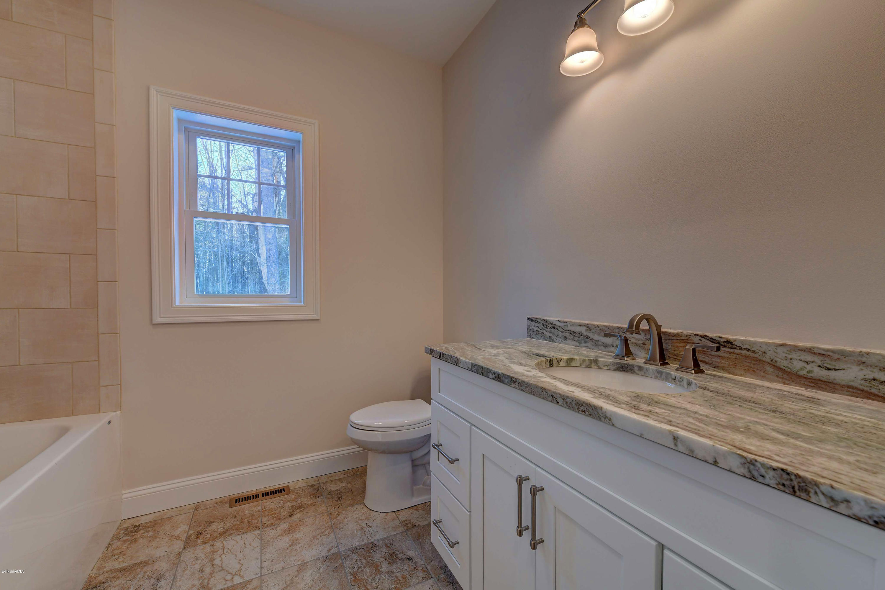 1 B West Dale Road Stockbridge, MA 01262 - Photo 22 of 26 a bathroom with a granite countertop toilet a sink and mirror