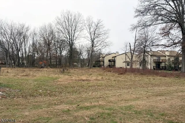 a backyard of a house with large trees and outdoor seating