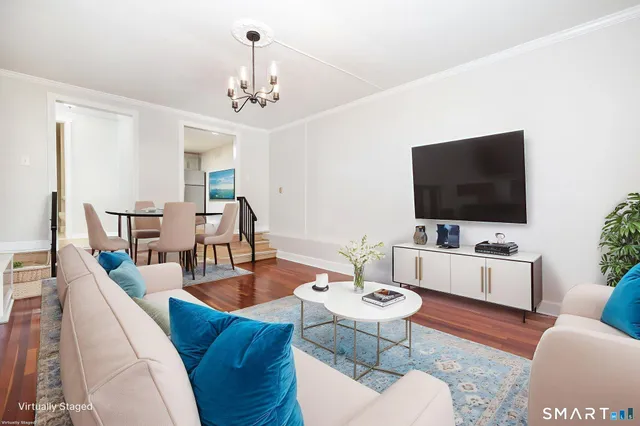 a living room with furniture a chandelier and a flat screen tv