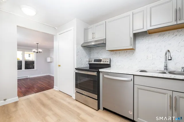 a kitchen with white cabinets and appliances