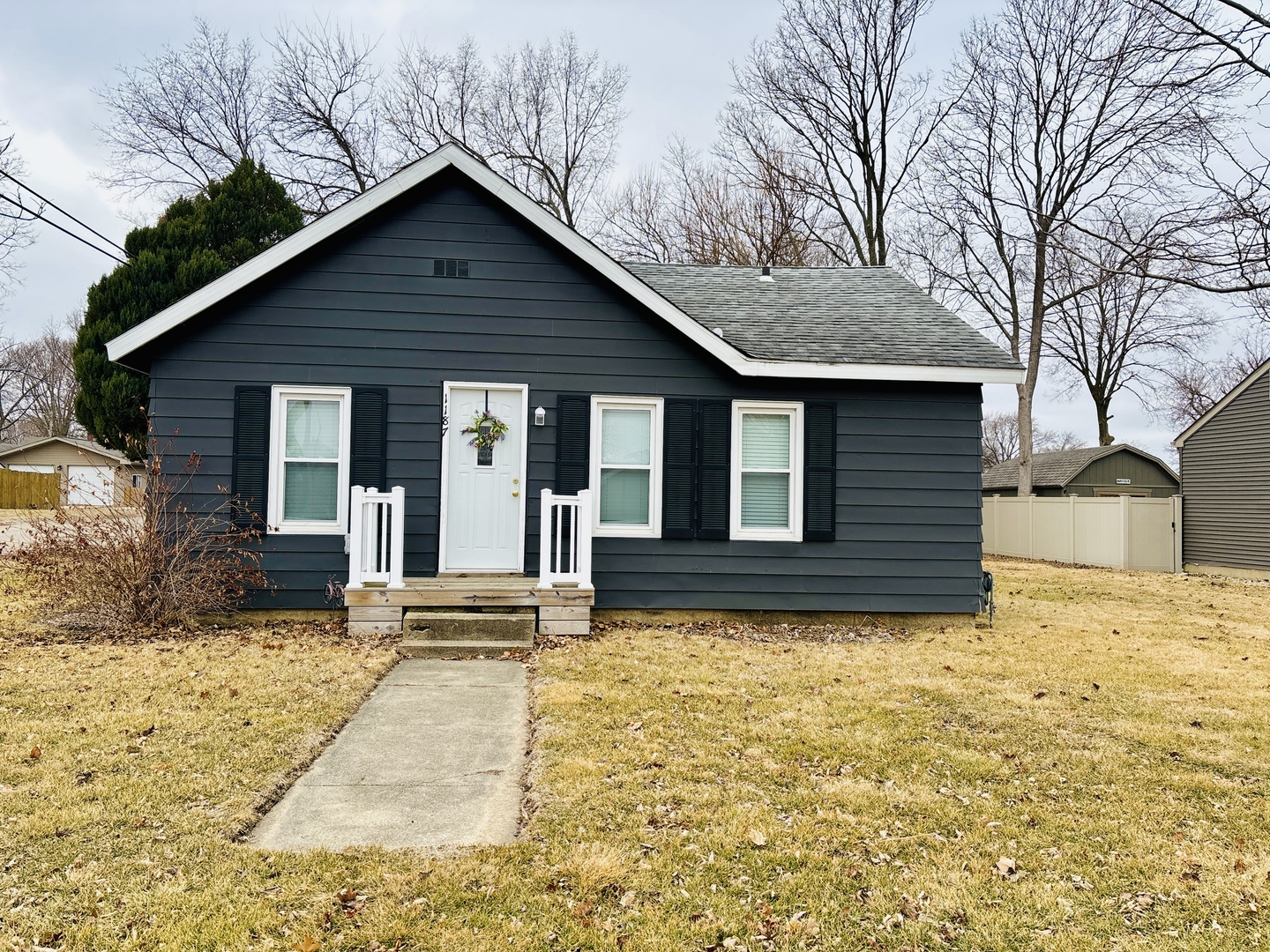 a front view of house with yard and trees around