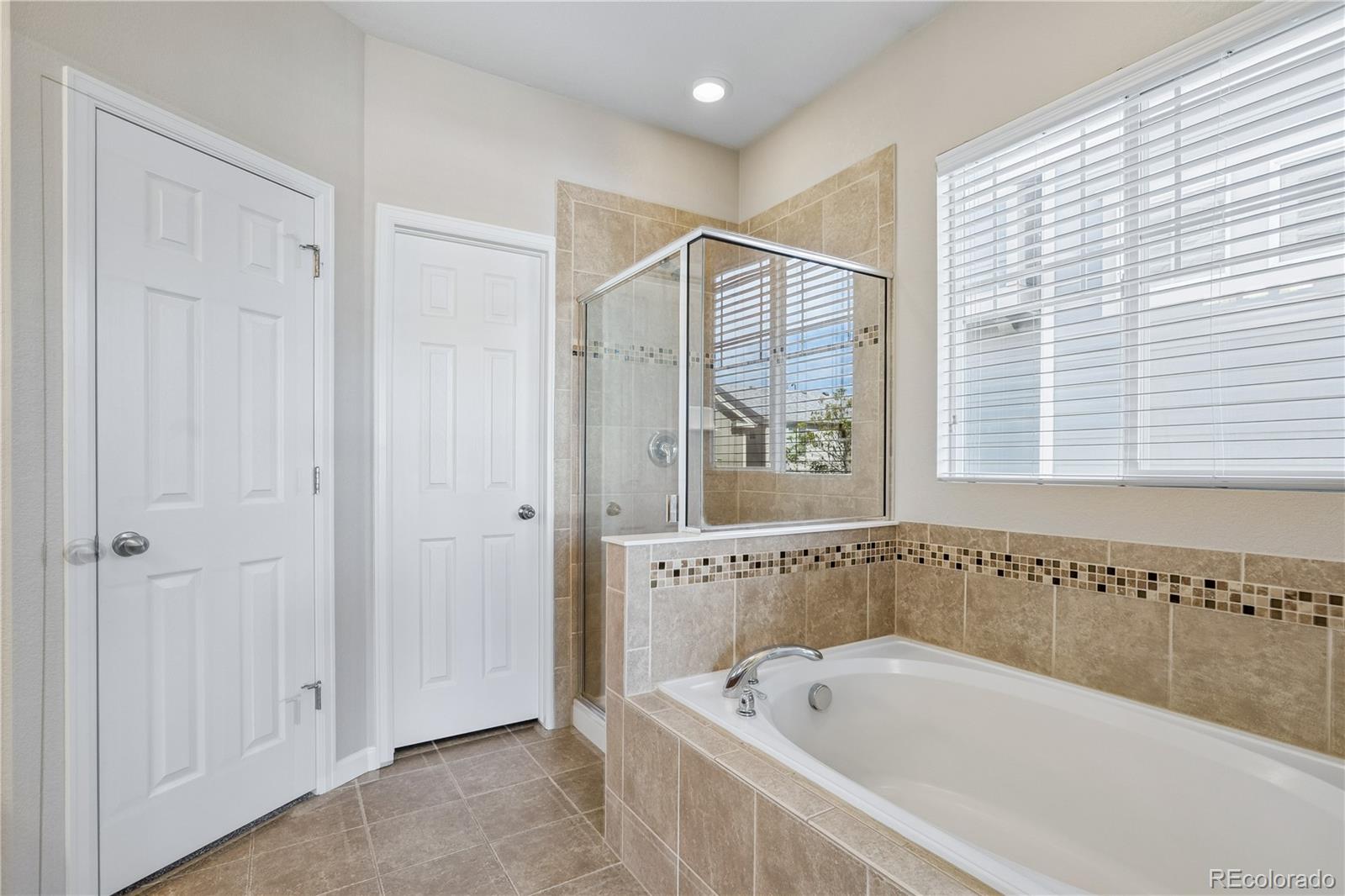 5031 South Rome Street Aurora, CO 80015 - Photo 18 of 39 a spacious bathroom with a bathtub and a shower