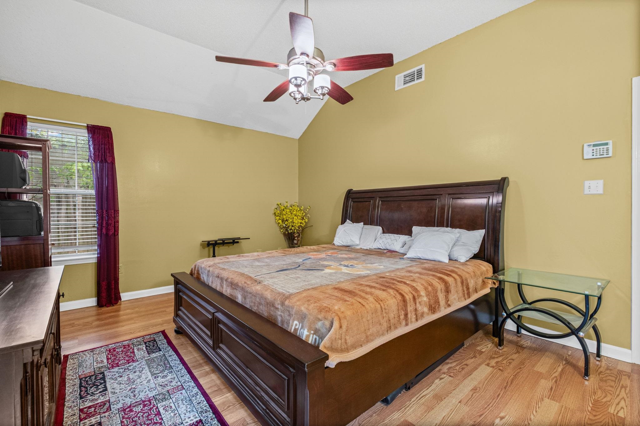 7788 Reese Road Memphis, TN 38133 - Photo 15 of 23 Room featuring a vaulted ceiling with a ceiling fan, wood-finish flooring, and a window with blinds, with patio access