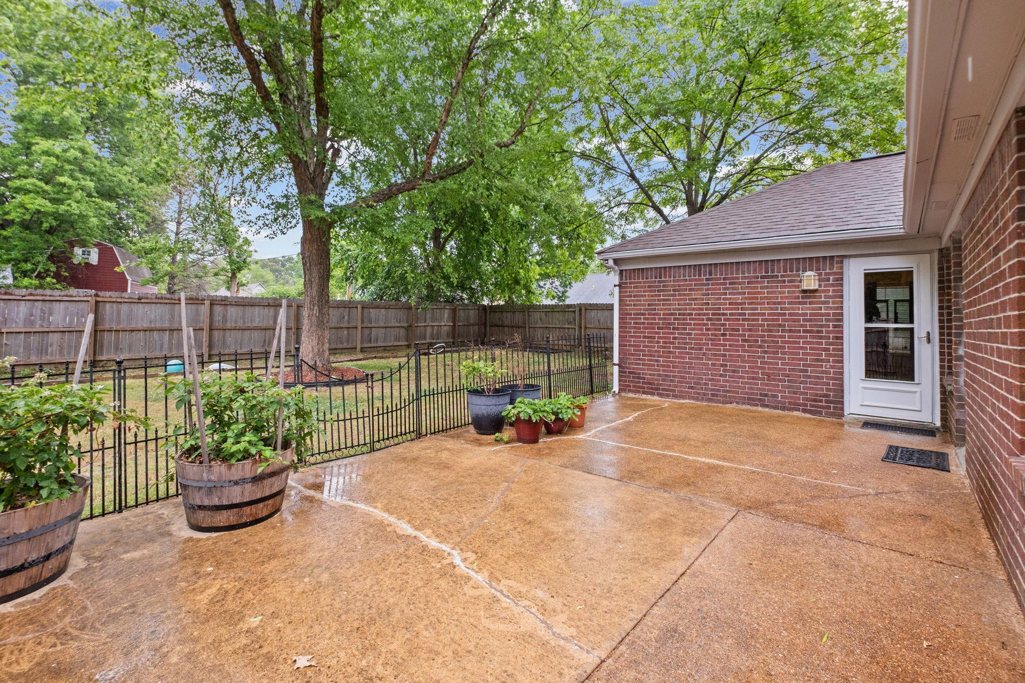 7788 Reese Road Memphis, TN 38133 - Photo 19 of 23 Expansive concrete patio area with a brick exterior wall and a white entry door