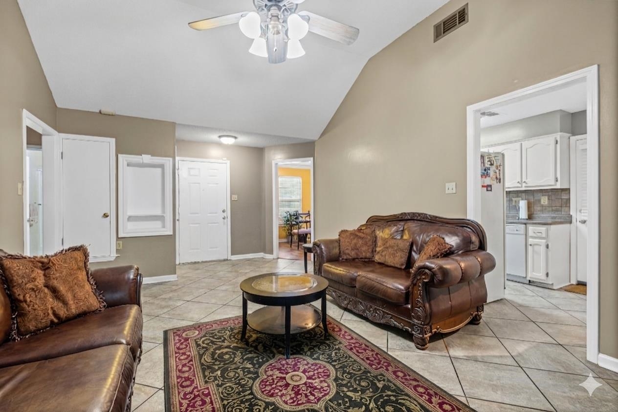 7788 Reese Road Memphis, TN 38133 - Photo 3 of 23 Vaulted ceiling living area featuring neutral paint, tile flooring, and a ceiling fan with integrated lighting
