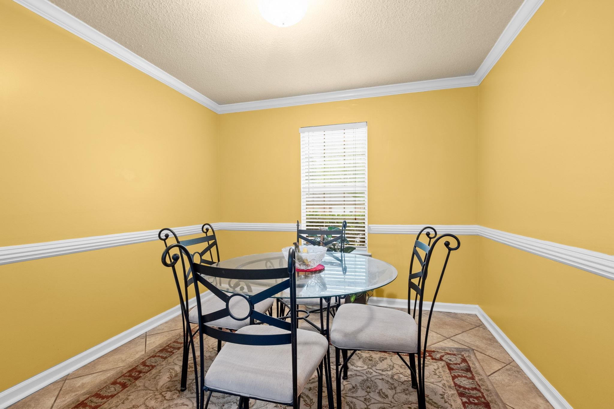 7788 Reese Road Memphis, TN 38133 - Photo 10 of 23 Dining area featuring a single window with blinds, crown molding, chair rail molding, and tile flooring
