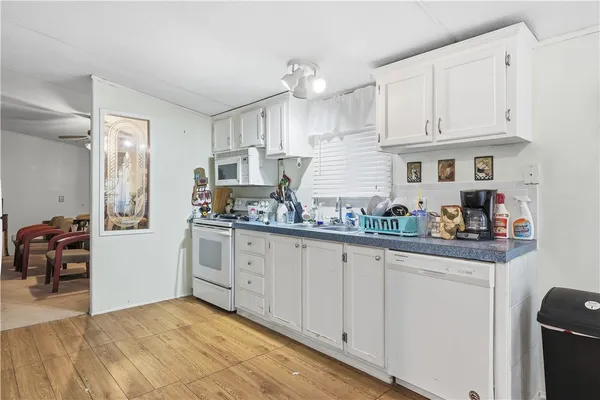 a kitchen with white cabinets and sink
