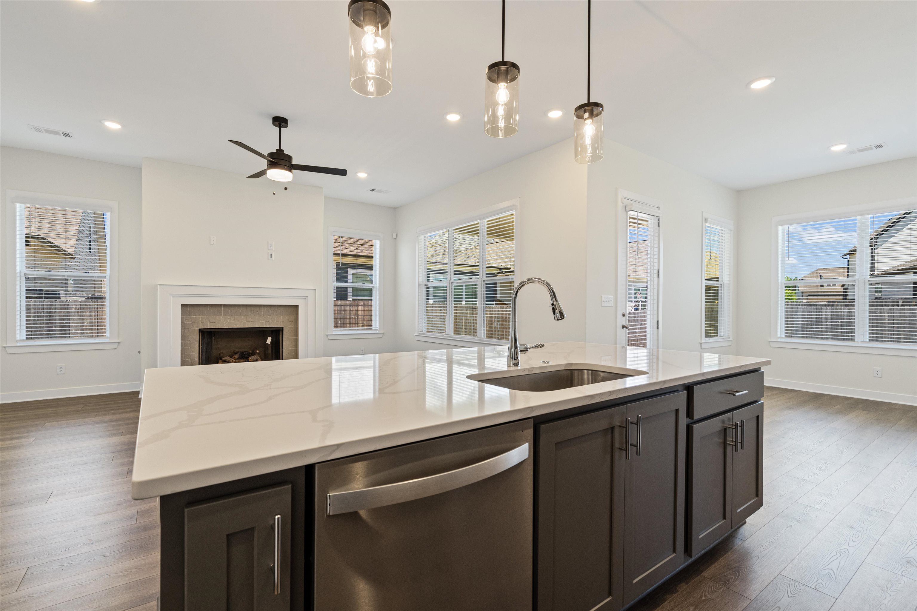 5666 Pleasant Pk Place Arlington, TN 38002 - Photo 16 of 27 Kitchen island with a light-toned countertop, integrated sink with a gooseneck faucet, and dark base cabinetry