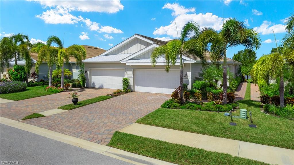 a front view of a house with a yard and potted plants