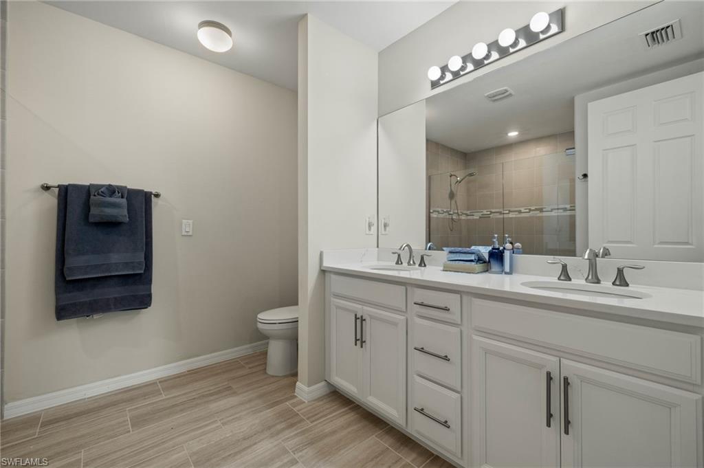 14680 Edgewater Circle Naples, FL 34114 - Photo 14 of 33 a bathroom with a double vanity sink and a toilet