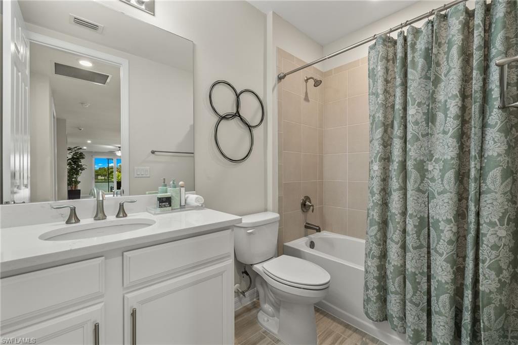 14680 Edgewater Circle Naples, FL 34114 - Photo 17 of 33 a bathroom with a toilet a sink and a mirror