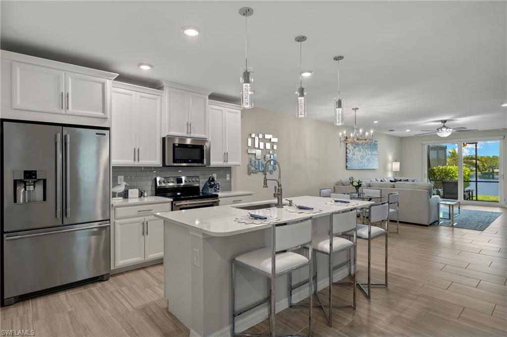 14680 Edgewater Circle Naples, FL 34114 - Photo 2 of 33 a kitchen with stainless steel appliances kitchen island granite countertop a sink and a refrigerator