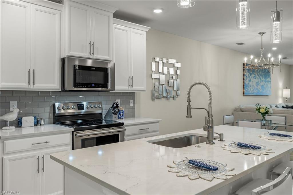 14680 Edgewater Circle Naples, FL 34114 - Photo 3 of 33 a kitchen with a sink a stove and microwave