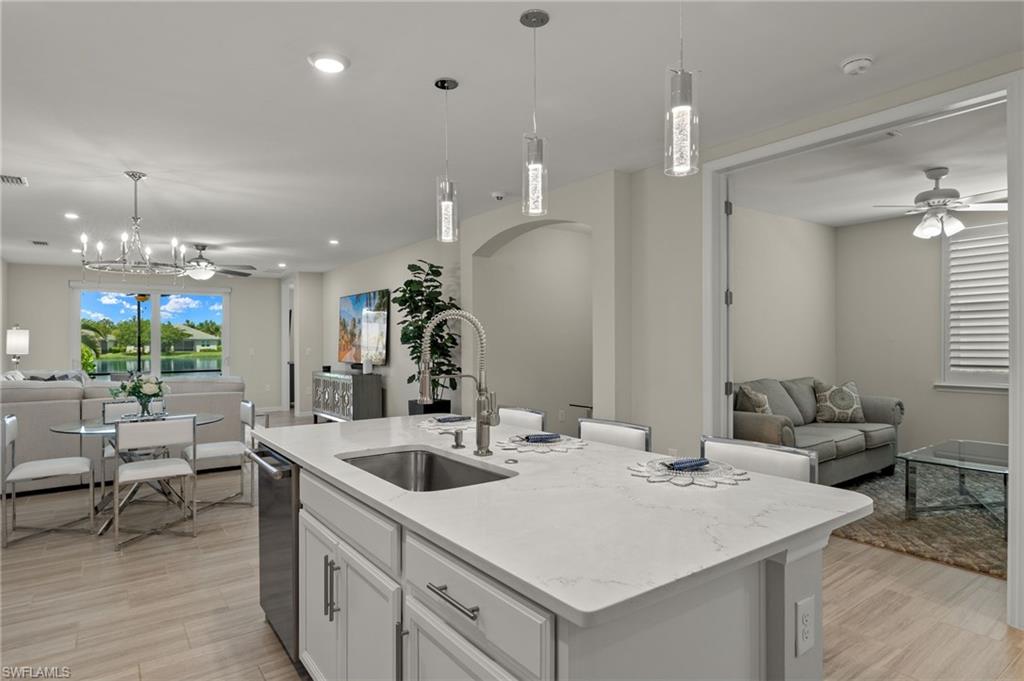 14680 Edgewater Circle Naples, FL 34114 - Photo 5 of 33 a kitchen with a sink a counter and chairs in it