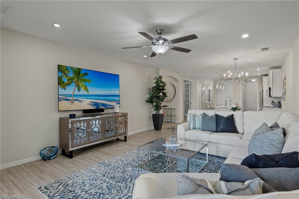 14680 Edgewater Circle Naples, FL 34114 - Photo 9 of 33 a living room with furniture and a flat screen tv