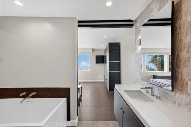 a bathroom with a tub sink and mirror