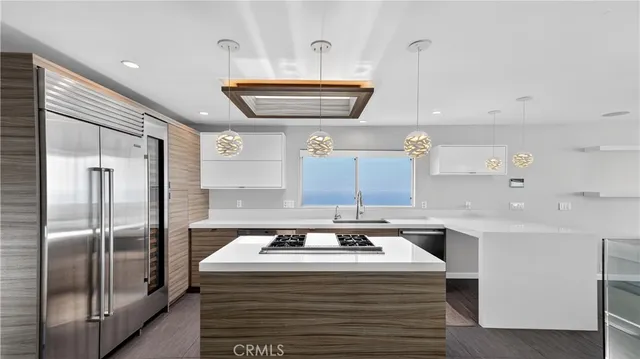 a kitchen with stainless steel appliances granite countertop a sink and a refrigerator