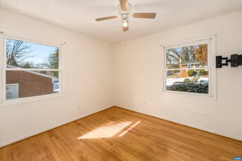an empty room with a window and ceiling fan