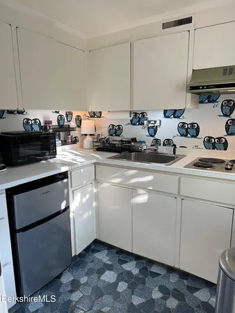 a kitchen with stainless steel appliances granite countertop a sink a stove and cabinets