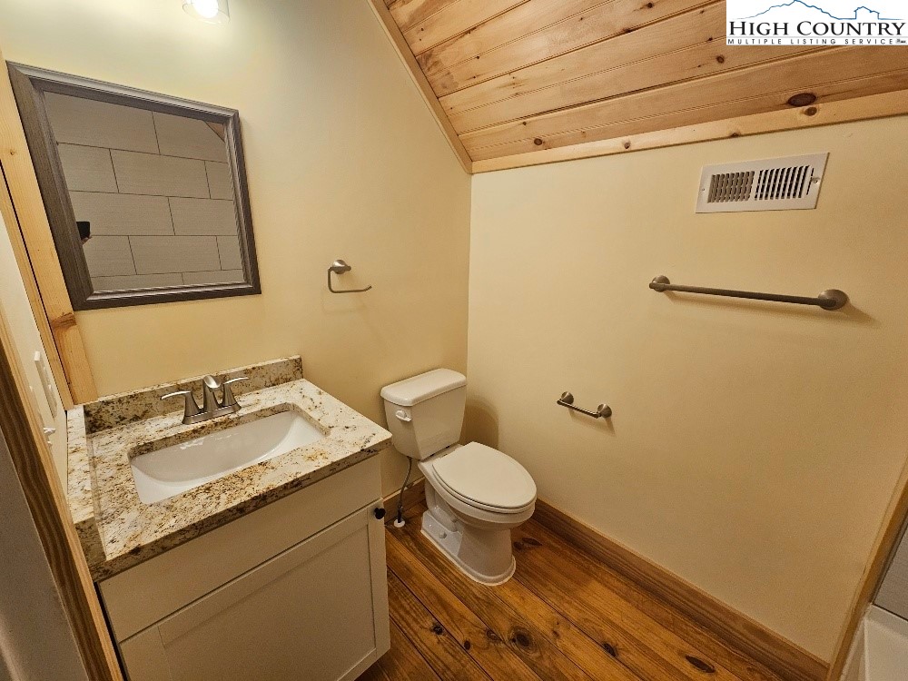 184 Presnell Road Sparta, NC 28675 - Photo 27 of 30 a bathroom with a granite countertop sink toilet and a mirror