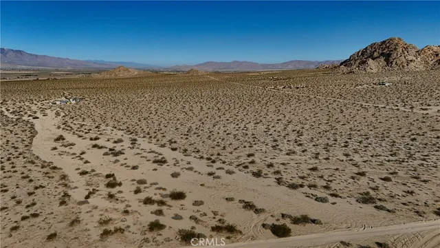 a view of a dry field with a mountain in the background
