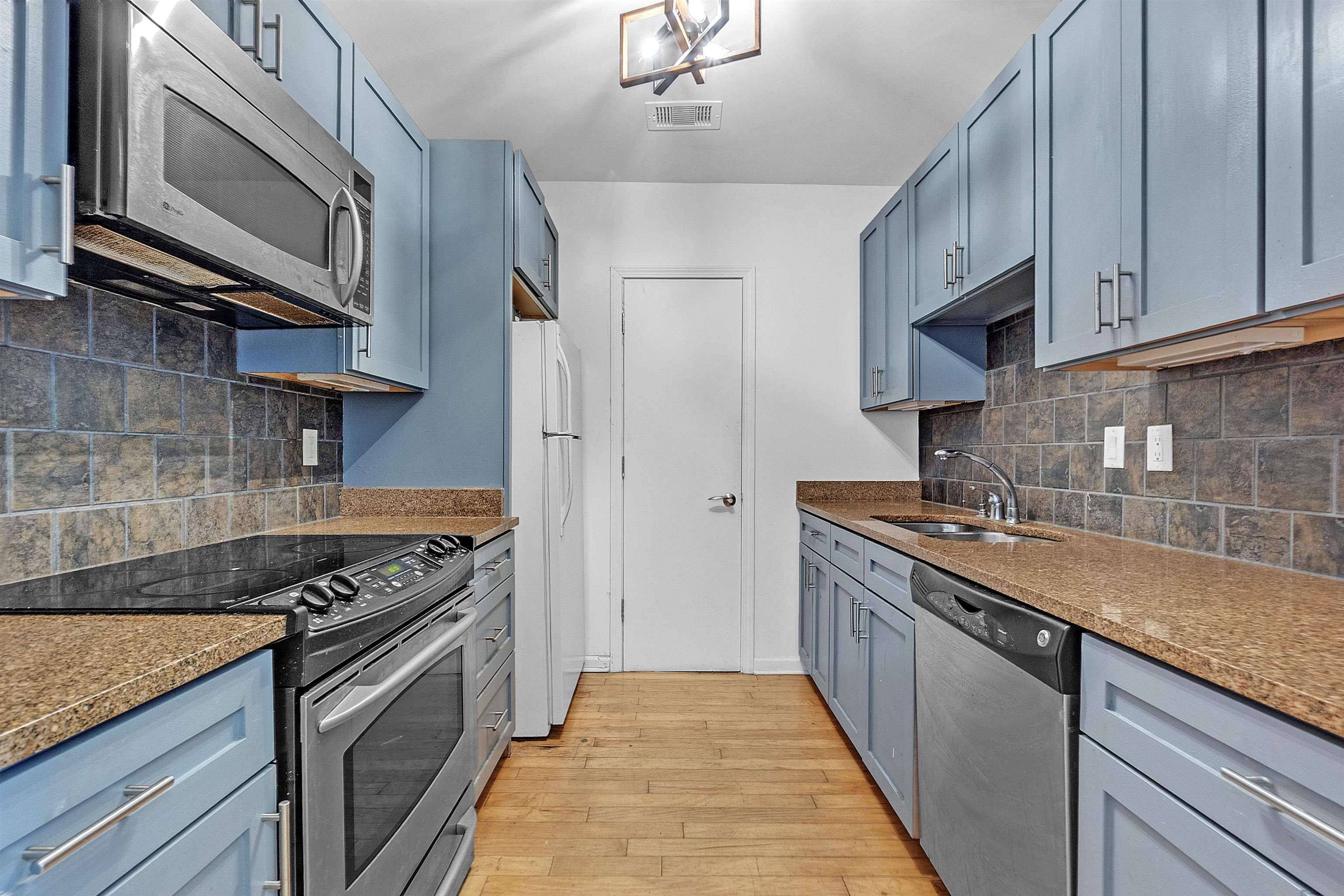 66 Monroe Avenue, Unit 606 Memphis, TN 38103 - Photo 3 of 9 a kitchen with stainless steel appliances granite countertop a sink a stove and a wooden cabinets