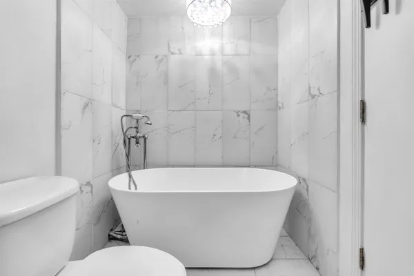 a white bath tub sitting next to a white toilet
