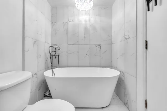 a white bath tub sitting next to a white toilet