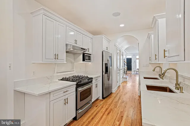 a kitchen with stainless steel appliances granite countertop a sink stove and refrigerator