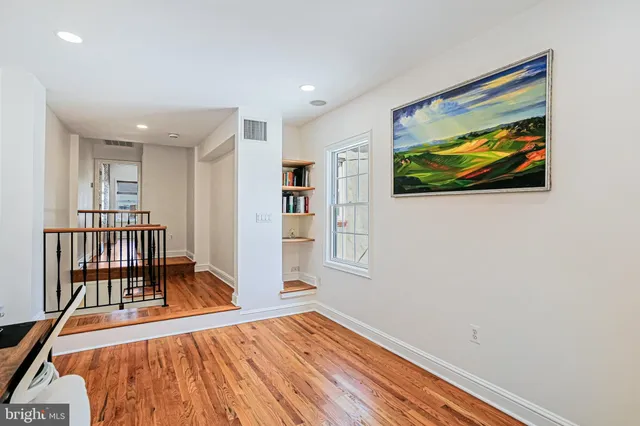 a view of a hallway with furniture and wooden floor