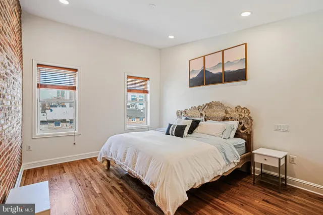 a bedroom with bed and wooden floor