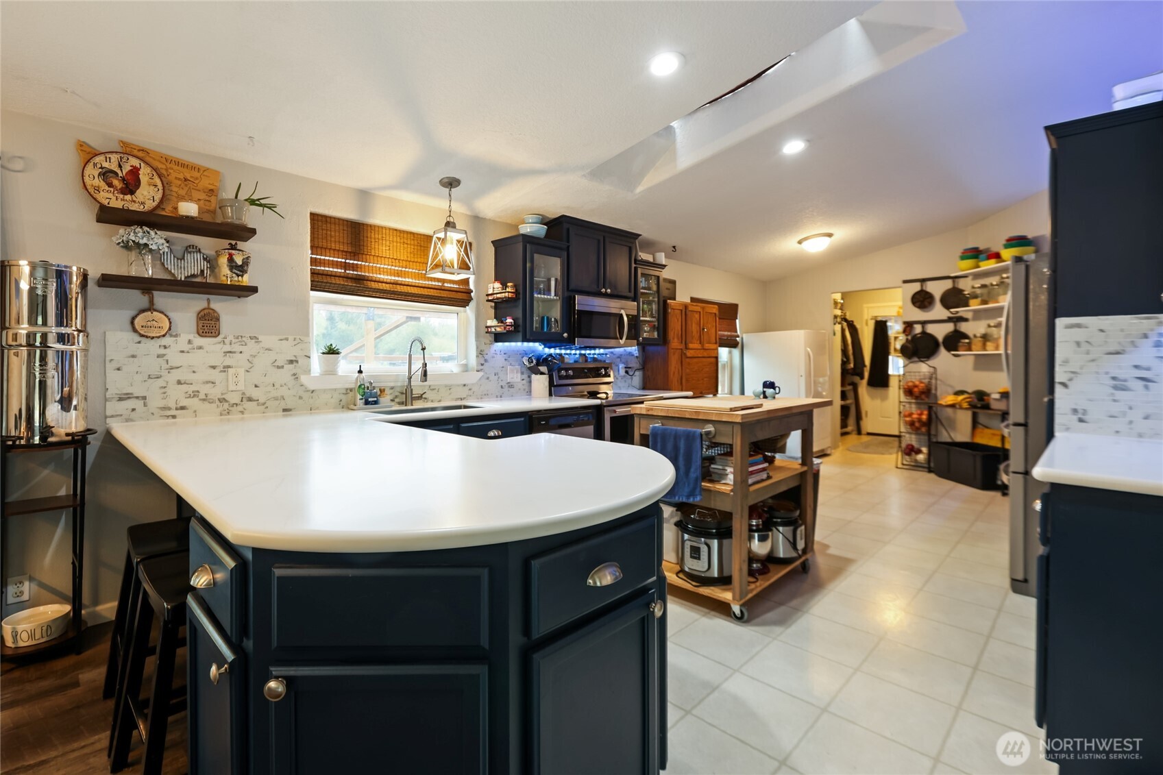 6509 176th Avenue Southwest Longbranch, WA 98351 - Photo 4 of 32 a kitchen with stainless steel appliances kitchen island granite countertop a sink a stove and a refrigerator with wooden floor