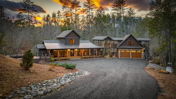 a view of house with outdoor space and trees in the background
