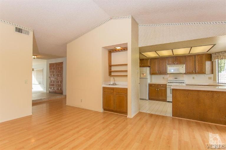 13681 Bear Valley Road Moorpark, CA 93021 - Photo 13 of 33 a view of a kitchen with a sink and dishwasher a stove top oven with wooden floor