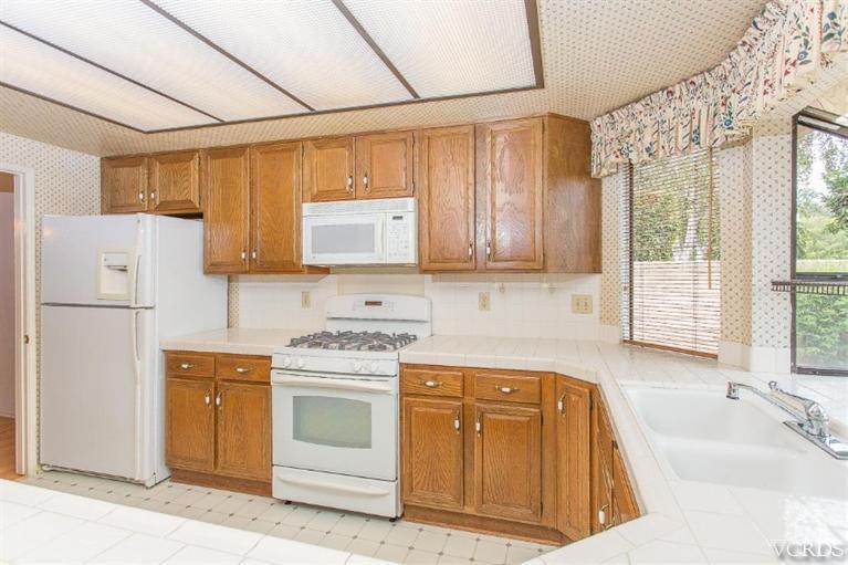 13681 Bear Valley Road Moorpark, CA 93021 - Photo 15 of 33 a kitchen with stainless steel appliances granite countertop a sink a stove a refrigerator a microwave oven with cabinets and wooden floor