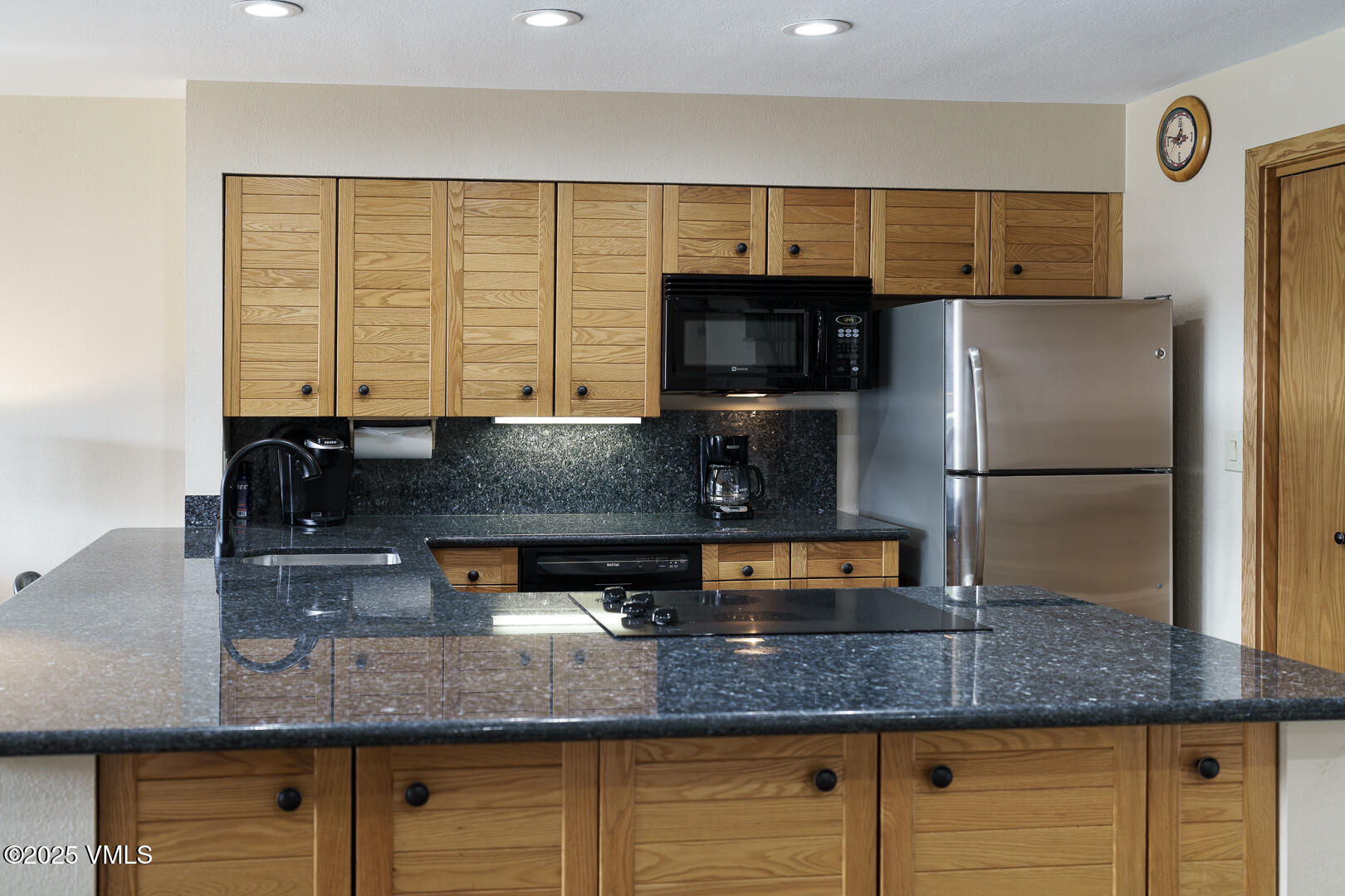 1121 Berry Creek Road, Unit B3 Edwards, CO 81632 - Photo 8 of 38 a kitchen with granite countertop a sink and a refrigerator