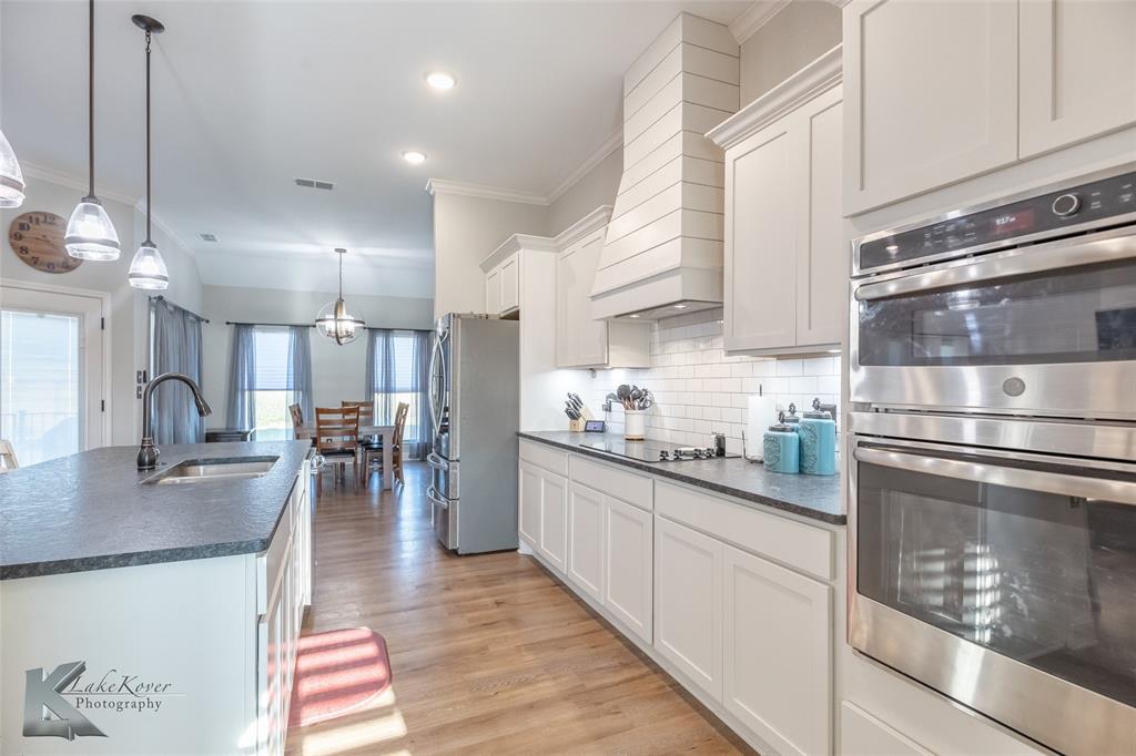 138 Lisa Lane Tuscola, TX 79562 - Photo 12 of 38 a kitchen with stainless steel appliances granite countertop a sink a stove and a wooden floors